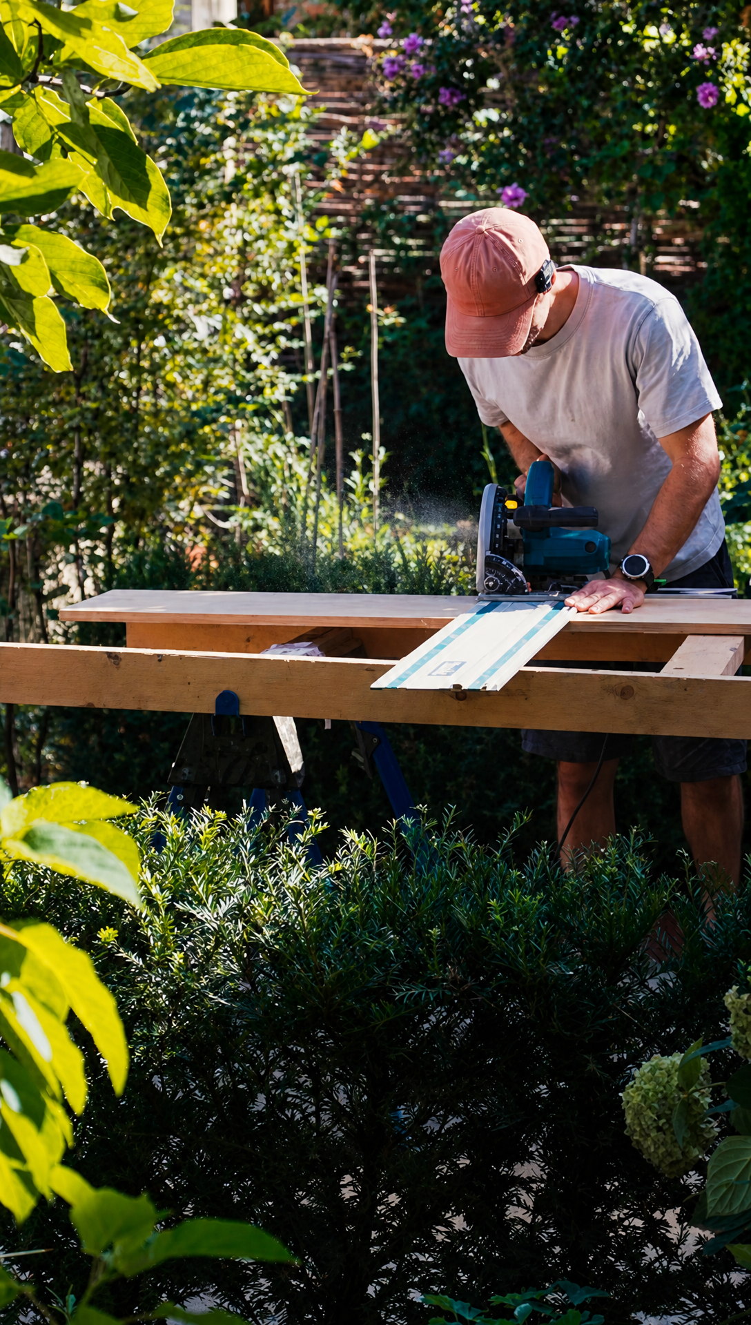 Hugo guiding a track saw along a rail across a plywood sheet, sawdust in the air