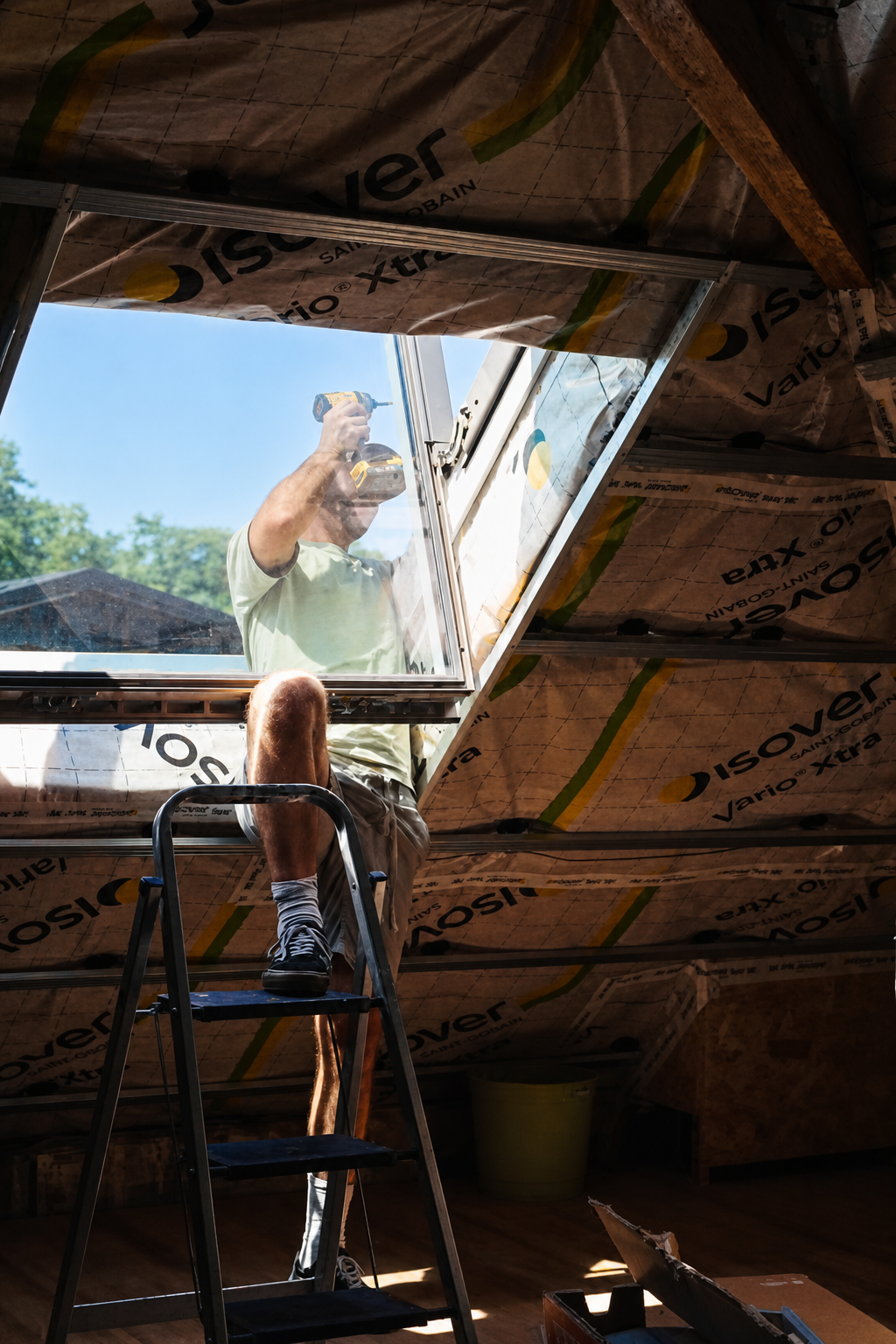 View up through an attic roof window with a figure working on the roof outside